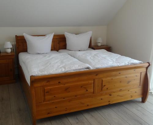 a wooden bed with two white pillows on it at Ferienwohnung Schwarzwald-Baar Blick in Donaueschingen