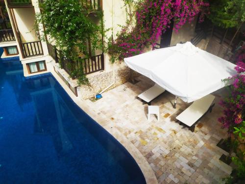 an overhead view of a pool with a white umbrella at Alya Hotel Göcek in Göcek
