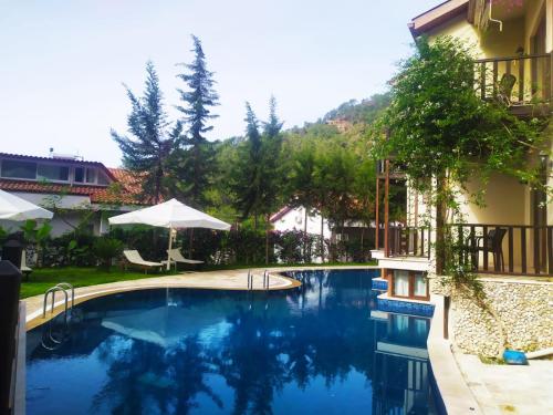 a swimming pool next to a building with at Alya Hotel Göcek in Göcek