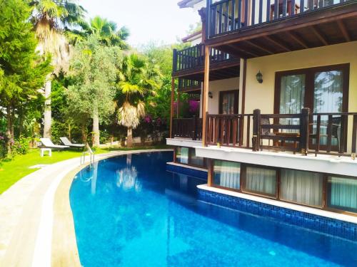 a house with a swimming pool next to a building at Alya Hotel Göcek in Göcek