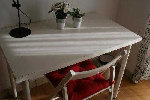 Una mesa blanca con dos macetas encima. en Casa Nipitella, en Catania