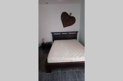 ein Schlafzimmer mit einem Bett mit einem Herz an der Wand in der Unterkunft Maison adossée in LʼAiguillon-sur-Vie