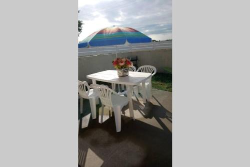 einen Tisch und Stühle mit Sonnenschirm auf einer Terrasse in der Unterkunft Maison adossée in LʼAiguillon-sur-Vie