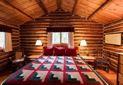 sypialnia z łóżkiem w drewnianym domku w obiekcie Jenny Lake Lodge w mieście Beaver Creek