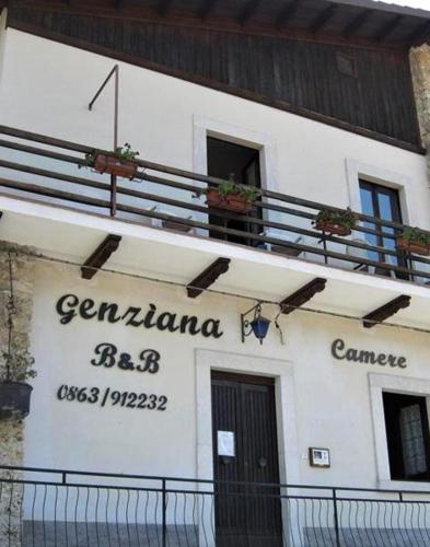 a white building with a balcony on top of it at Genziana B&B by VM in Opi
