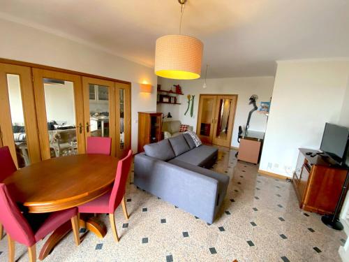 a living room with a couch and a wooden table at Beachside Feel Full Apartment Beach & Casino in São Félix da Marinha