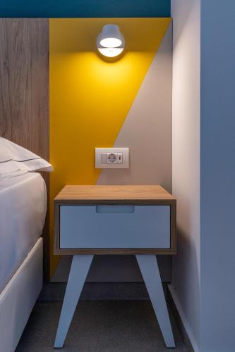 a bed room with a table and a yellow wall at Olympia Hotel in Kos Town