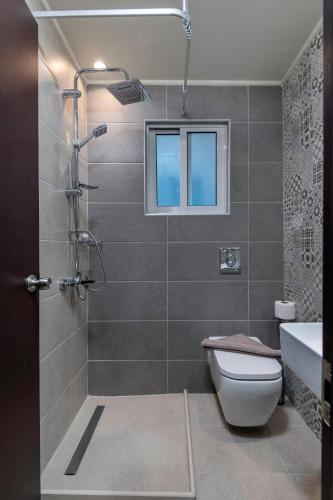 a bathroom with a shower with a toilet and a sink at Olympia Hotel in Kos Town