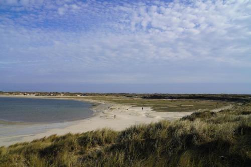 a beach with people on the sand and the water at Hotel Den Burg in Den Burg