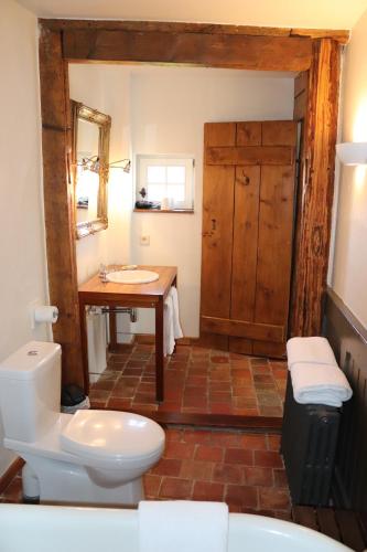 a bathroom with a toilet, sink and tub at Hotel de Charme 'zum Schiff' in Iffezheim