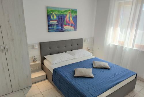 a bedroom with a blue bed with two pillows on it at Apartments Riba in Vis