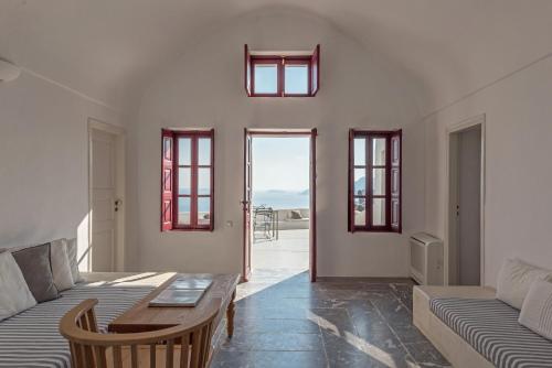 un salon avec un canapé et une table dans l'établissement Parathira cave houses oia by cycladica, à Oia