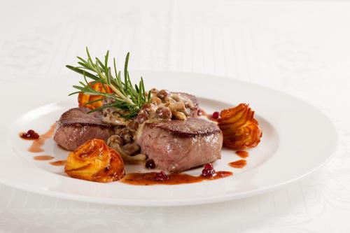 a plate of meat and vegetables on a white plate at Hotel Konradshof in Seewald