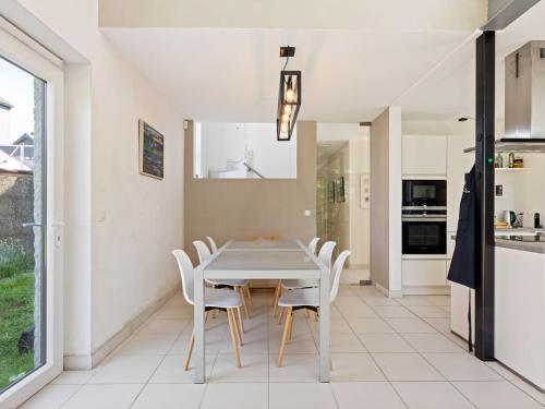 uma cozinha e sala de jantar com uma mesa branca e cadeiras em Sun kissed Villa in Kobbegem with Private Garden 