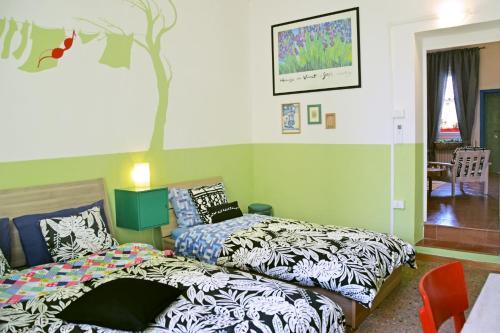 1 dormitorio con 2 camas y un árbol en la pared en Ottavo Portone, en Bolonia