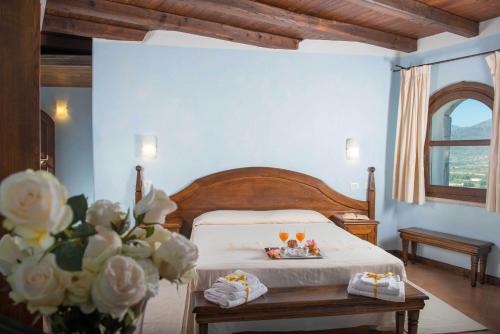 - une chambre avec un lit et une table avec des boissons dans l'établissement Tenuta Su Vrau, à Posada