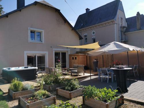 a backyard with a hot tub and a house at Le pavillon de l'herboriste 14p jacuzzi jardin in Tintigny