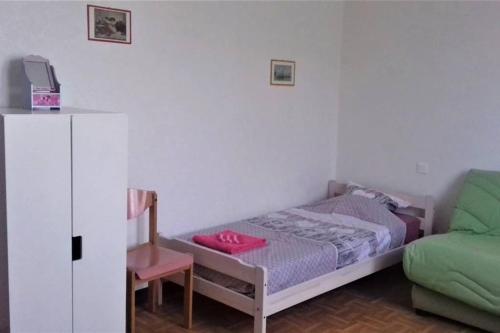 une petite chambre avec un lit et une chaise dans l'établissement Spacieux appartement proche centre et piscine, à Condom