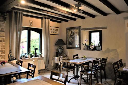 un comedor con mesas, sillas y ventanas en B&B De Dubbelmolen, en Tongeren