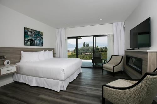 a hotel room with a bed and a television at The Inn at Therapy Vineyards in Naramata