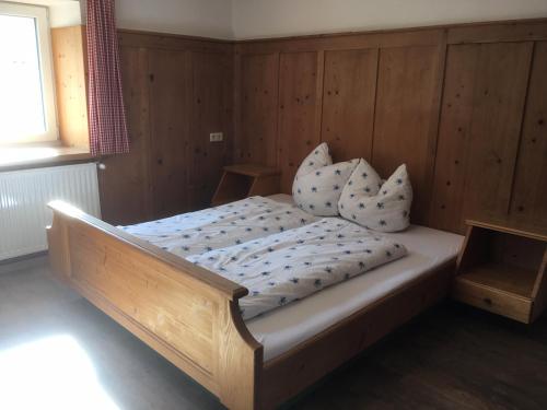 een slaapkamer met een houten bed met kussens erop bij Ferienwohnung Sonnenschein in Galtür