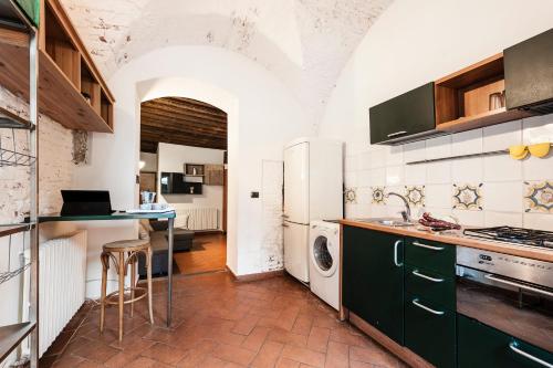 a kitchen with a refrigerator and a stove top oven at Hostly - Garden House near the Tower - Historical house with Private Garden in Pisa