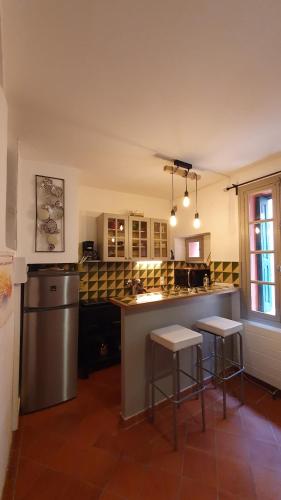a kitchen with two bar stools and a counter top at Au coeur de Collioure in Collioure