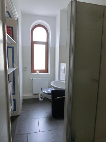 een badkamer met een douche en een bad en een raam bij FeWo zwischen Augustusburg und Freiberg in Eppendorf