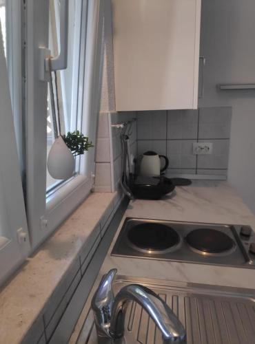 a kitchen with a stove and a sink and a window at Apartmani Lučica in Jezera