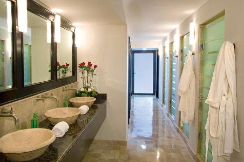 a bathroom with two sinks and a hallway at Luxury Suites By Estrella del Mar in Mazatlán