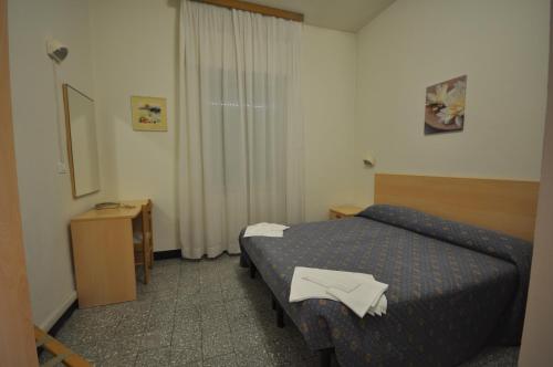 ein kleines Hotelzimmer mit einem Bett und einem Spiegel in der Unterkunft Hotel Roxy Floridiana in Rimini