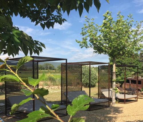 un jardin avec une pergola et un arbre dans l'établissement Le Vieux Portail, à Saint-Saturnin-lès-Apt