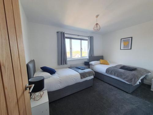 a bedroom with two beds and a window at Hillview home from home in Lackenby