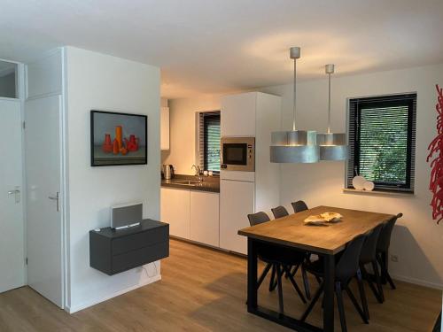 a dining room and kitchen with a table and chairs at Vakantiehuisje Time Out in Zelhem