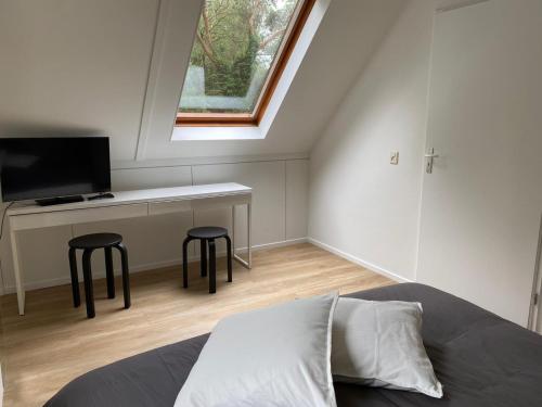 a bedroom with a bed with two stools and a window at Vakantiehuisje Time Out in Zelhem
