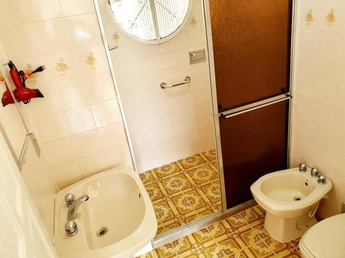 a bathroom with a shower and a toilet and a sink at Pousada das Hortensias in Conservatória
