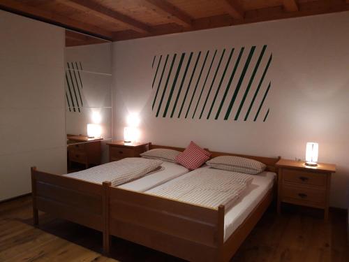 a bedroom with two beds and two lights on the wall at Unterhohnenhof in Triberg