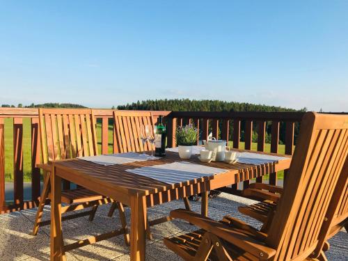 a wooden table on a deck with two chairs at Horský apartmán Václavov in Vaclavov u Bruntalu