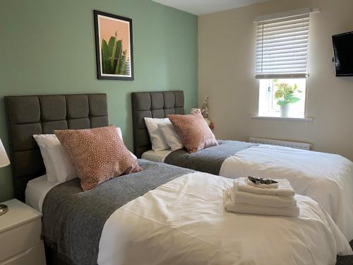 a bedroom with two beds and a window at City Bridge Townhouse 4 in Newcastle upon Tyne