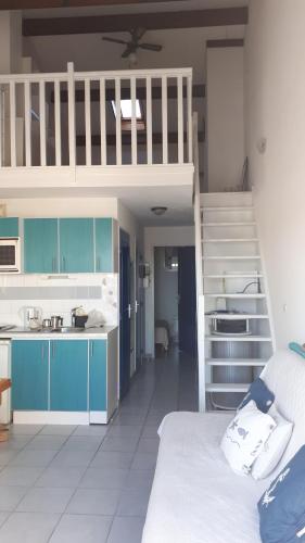 une chambre avec des lits superposés et une cuisine avec un escalier dans l'établissement Les sardines, à Sète