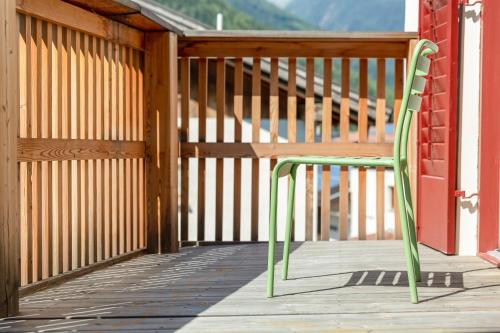 a green chair sitting on a wooden deck at Zum Riesen Historic Refugium in Laces