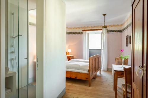 een slaapkamer met een bed en een glazen deur bij Zum Riesen Historic Refugium in Laces