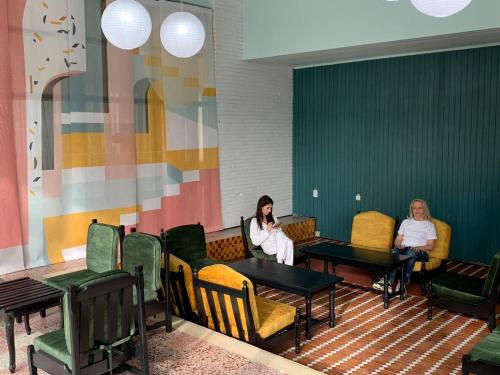 two women sitting at tables in a waiting room at Hotel Mures in Saturn