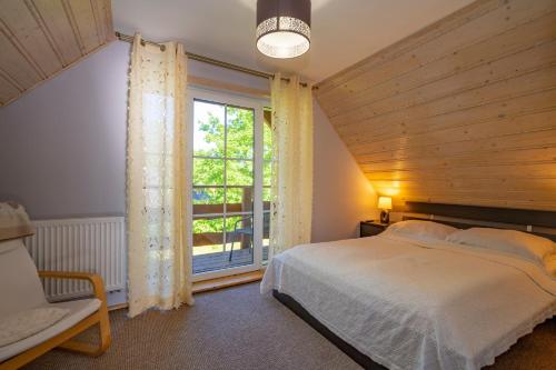 um quarto com uma cama e uma grande janela em Chata Na Zaciszu em Szklarska Poręba