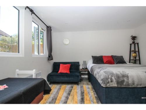 a bedroom with two beds and a chair and a window at StayZo - Crofton Park - Central London refurbished Studio in London