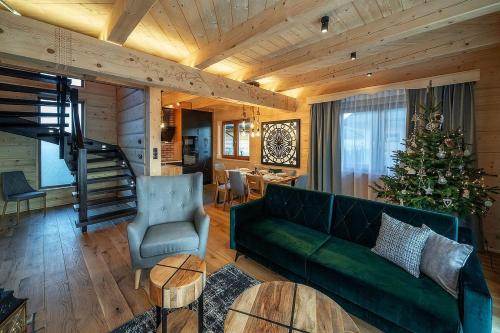 a living room with a green couch and a christmas tree at "Osada Guty" - Domki z Jacuzzi - Szaflary in Szaflary