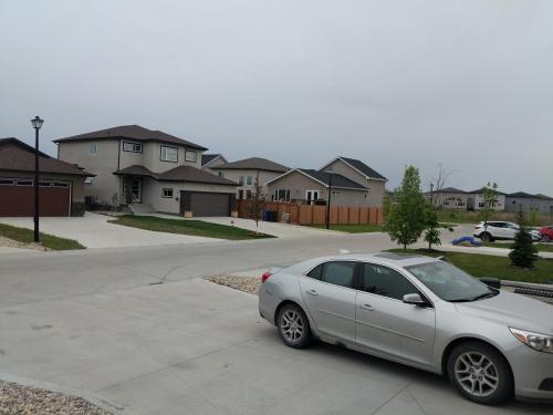 a silver car parked in the driveway of a house at The Home Sweet Home in Winnipeg