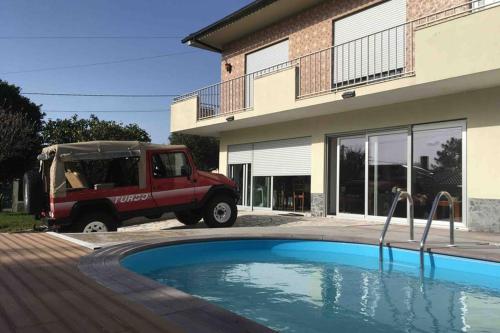 a truck parked in front of a house with a pool at Casa da Cavada - 6 quartos-rooms in Caminha