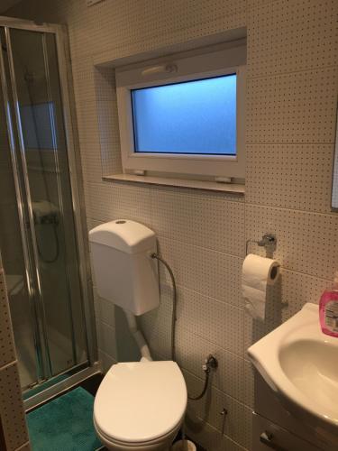 La salle de bains est pourvue de toilettes et d'une télévision murale. dans l'établissement Nasza Polana Pokoje Noclegi Pieskowa Skała Ojców, à Pieskowa Skała