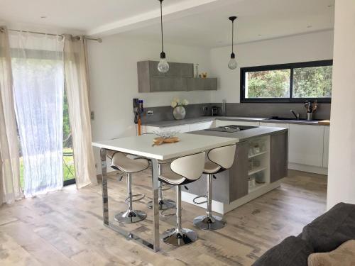 a kitchen with a table and two stools at Casa Serena in Cuttoli-Corticchiato